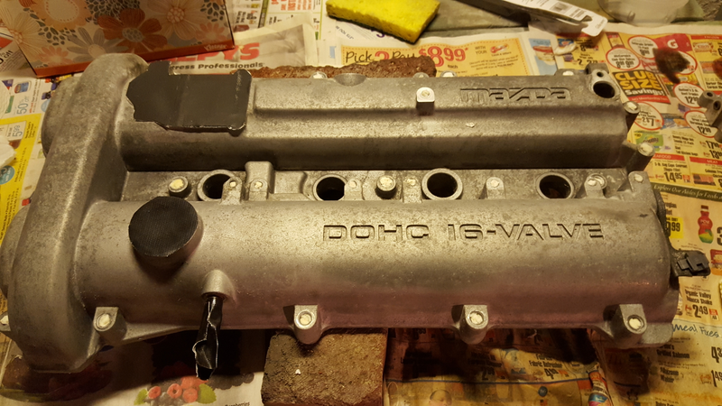 Prepping the valve cover, including plugging the holes for all of the bolts with wet tissues.